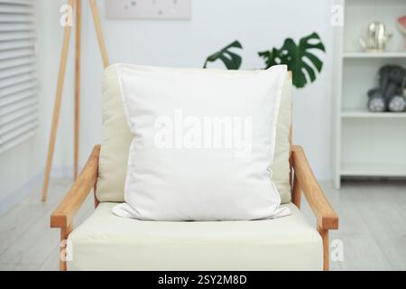 Blank soft pillow on cozy armchair at home Stock Photo