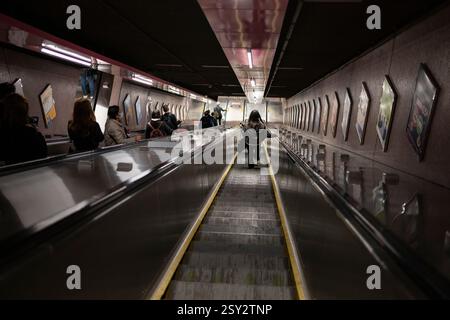 Hong Kong MTR Escalator. Commuters ascend a long, deep escalator in a Hong Kong subway station, illustrating the speed and movement of modern city. Stock Photo