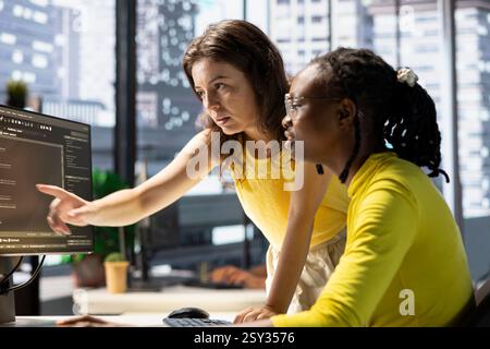 Manager correcting employee mistakes while conducting code review to fix bugs, identifying performance and technical issues with company software. Team leader supervising IT worker optimizing code Stock Photo