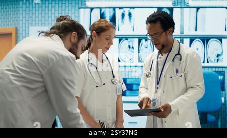 Medical staff collaborates on diagnostic procedures and treatment plans. Radiology specialists work on accurate diagnosis and effective disease prevention, healthcare industry insurance. Camera A. Stock Photo