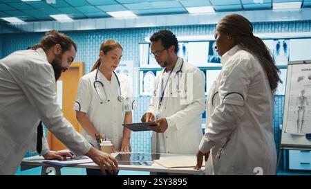 Medical staff collaborates on diagnostic procedures and treatment plans. Radiology specialists work on accurate diagnosis and effective disease prevention, healthcare industry insurance. Camera B. Stock Photo
