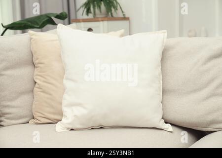 Blank soft pillow on cozy couch indoors Stock Photo