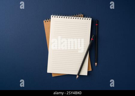 Top view of notebook and pencil on blue background Stock Photo
