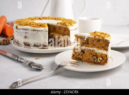 The Cut piece of carrot cake lies on the plate. White background. carrot cake day Stock Photo