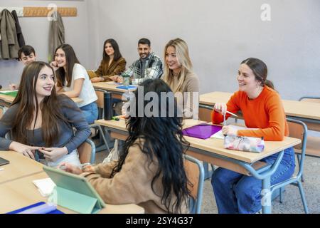 Cheerful university students are actively participating in a class, engaging in discussions and collaborating on their studies at their institute Stock Photo