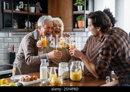 Multi generation multiethnic family having fun, talking around a festive kitchen table. Stock Photo