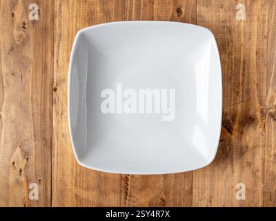 Empty square white plate on wooden background. Top view Stock Photo