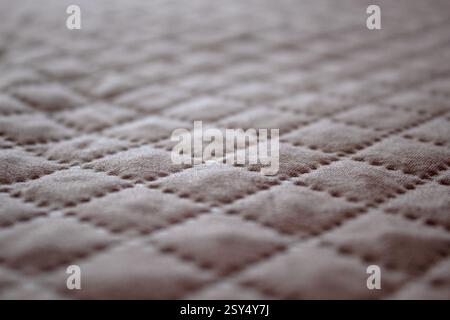 Light quilt bedcover with relief Narrow focus line, shallow depth of field macro Stock Photo