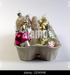 Old soviet decoration on the Christmas tree, glass toy strawberry and pine cone mushroom close up in egg box isolated on white background Stock Photo