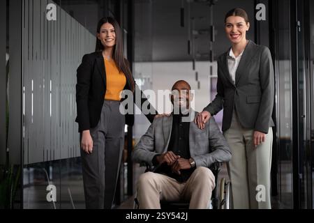 Professional team portrait featuring a diverse group of businesspeople, including a man in a wheelchair, in a modern office setting. Concept of Stock Photo