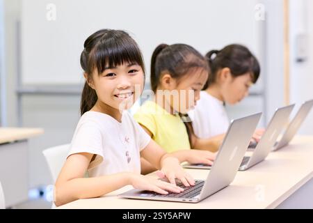 Japanese Children Using Laptops In Classroom Stock Photo