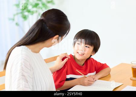 Japanese Mother And Son Doing Homework At Home Stock Photo