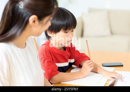 Japanese Mother And Son Doing Homework At Home Stock Photo