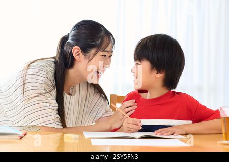 Japanese Mother And Son Doing Homework At Home Stock Photo