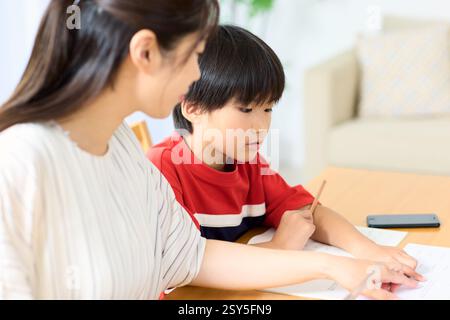Japanese Mother And Son Doing Homework At Home Stock Photo