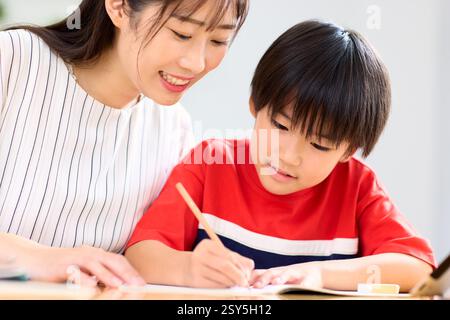 Japanese Mother And Son Doing Homework At Home Stock Photo