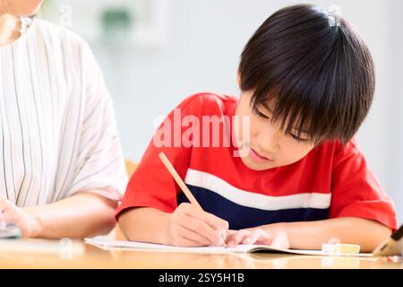 Japanese Mother And Son Doing Homework At Home Stock Photo
