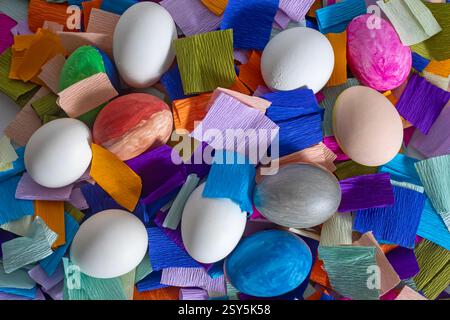 Top view of easter eggs with various designs on colorful pieces of paper create a festive atmosphere, perfect for seasonal celebrations and cheerful a Stock Photo
