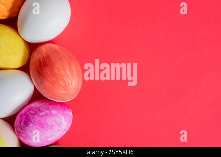 Brightly colored Easter eggs on a vibrant red background. Perfect for a seasonal or holiday celebration. Stock Photo