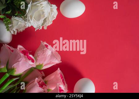 A vibrant Easter arrangement featuring delicate pink roses and eggs on a dark red background. Perfect for Easter celebrations. Stock Photo