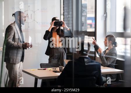 Business professionals in a modern office collaborate on an AI project. Woman explores virtual reality while colleagues discuss strategies. Concept of Stock Photo