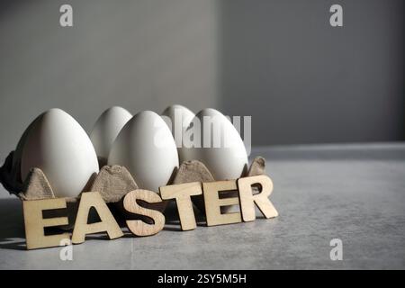 easter decor with wooden caption and eggs in paper box Stock Photo
