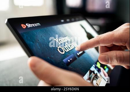Stream with tablet. Movie or video on laptop. Watching series. Streaming service content on screen. TV or VOD subscription. Stock Photo