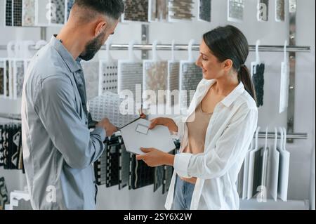 Standing and looking for new materials for home. Woman and man is in the store of goods. Stock Photo