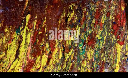 An asbtract textured painting of red, yellow and green paint that looks as though it is dripping down the surface of the picture Stock Photo