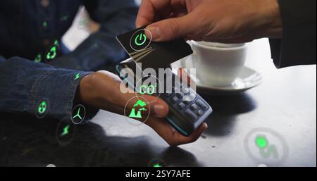 Image of network of eco icons over caucasian man paying with card Stock Photo