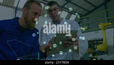Image of globe with connections and icons over diverse engineers in factory Stock Photo