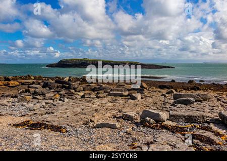 View looking from the beach across the channel Y Swnt towards Ynys Moelfre a small island off the coast of north east Anglesey in North Wales UK. Stock Photo