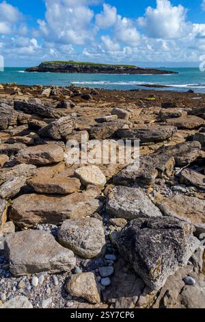 View looking from the beach across the channel Y Swnt towards Ynys Moelfre a small island off the coast of north east Anglesey in North Wales UK. Stock Photo