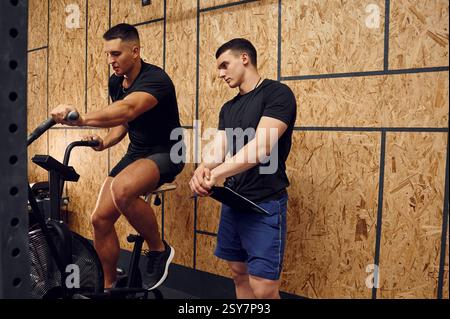 Sportive man doing cardio exercises on the bicycle. Stock Photo