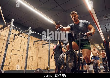 Sportive man doing cardio exercises on the bicycle. Stock Photo