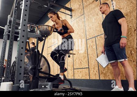 Endurance exercises. Sportive woman doing cardio exercises on the bicycle. Stock Photo