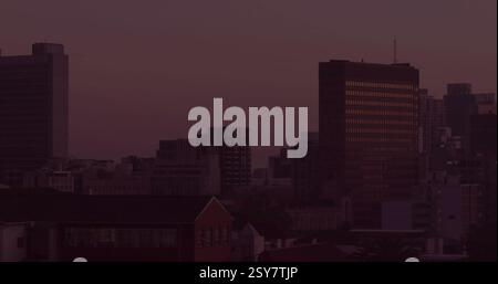 Processing data and recovering database image over cityscape at dusk Stock Photo