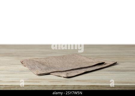 Gray napkin on wooden table against white background Stock Photo