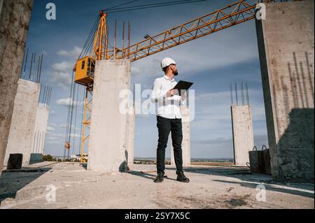Inspector with notepad is standing on the construction site. Stock Photo