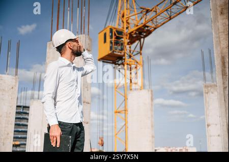 Inspector with notepad is standing on the construction site. Stock Photo