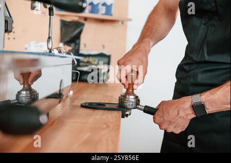 Preparing coffee by special tool. Barista in the cafe. Close up view. Stock Photo