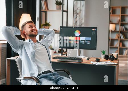 Designer is sitting by the computer and using graphics tablet with stylus. Stock Photo