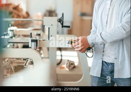 Modern printing machine. Typography worker in white clothes is indoors. Stock Photo