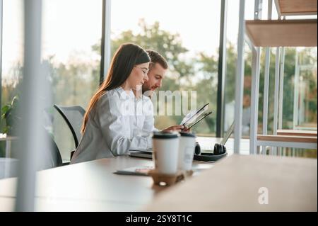 Side view. Man and woman are working in the modern office together. Stock Photo