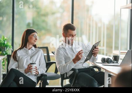 Sharing ideas. Man and woman are working in the modern office together. Stock Photo