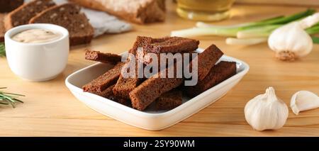 Tasty rye croutons on wooden table Stock Photo