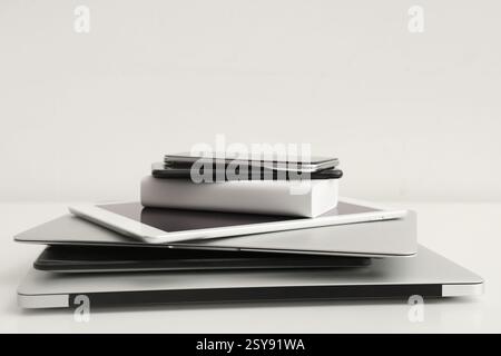 Stack of different modern gadgets on light background Stock Photo