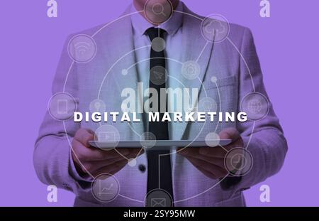 Digital marketing. Businessman holding tablet computer, toned in violet. Scheme with icons around device Stock Photo