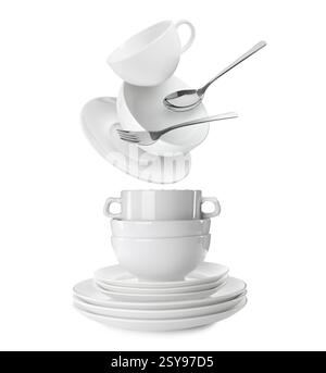 Clean dishware and silverware flying over tableware on white background Stock Photo