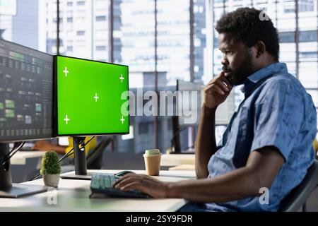 Programmer conducting tests on isolated screen computer to optimize machine learning models for performance and accuracy. IT specialist in office analyzing complex AI data on chroma key PC Stock Photo